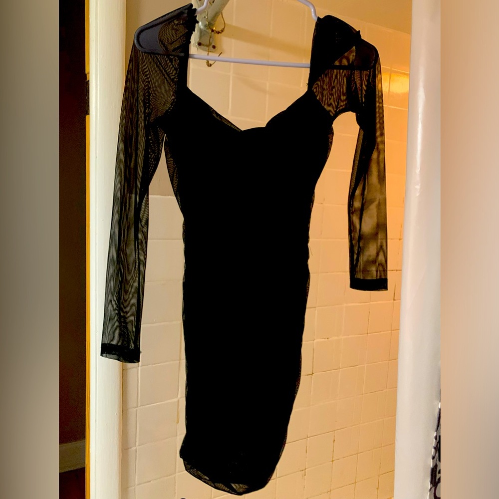 Woman’s black fitted dress with long sheer sleeves